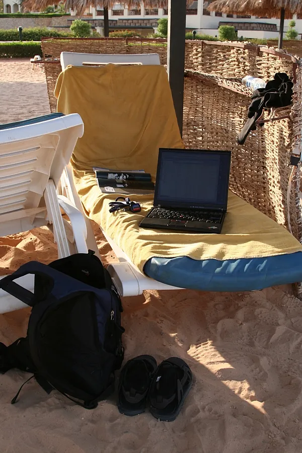Digital nomad working on a laptop at a beach hostel